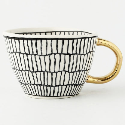 Skorter | Cup with abstract geometric pattern and gold handle