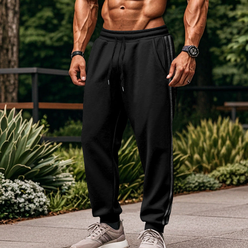 Herrbyxor med sportiga joggingbyxor med elastisk midja och kontrastränder på sidan.